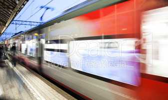 Motion blurred speed moving railroad train at railway station platform