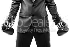 Businessman boxer in black suit wearing sport boxing gloves