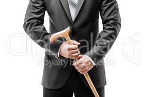 Businessman in black suit holding walking cane stick