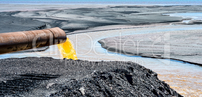 The industrial wastewater is discharged from the pipe into the water