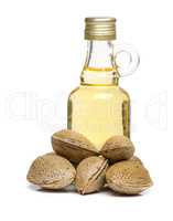 Isolated Almonds oil in a glass bottle with some almonds