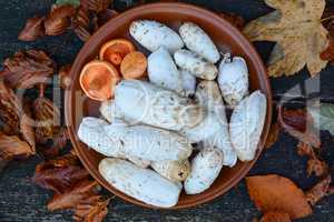 Edible wild mushrooms in a clay plate, top view