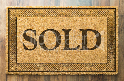 Sold Welcome Mat On A Wood Floor Background