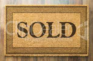 Sold Welcome Mat On A Wood Floor Background