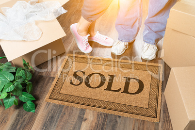 Man and Woman Standing Near Sold Welcome Mat, Moving Boxes