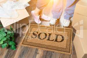 Man and Woman Standing Near Sold Welcome Mat, Moving Boxes