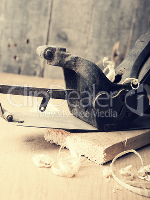 Old used wood plane on work bench