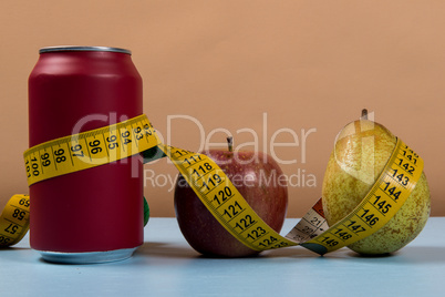 healthy life contrast with can of soda and fruit with a tape measure