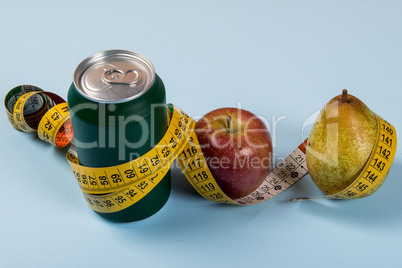 healthy life contrast with can of soda and fruit with a tape measure