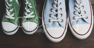 green and blue textile sneakers on a brown wooden surface