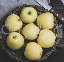 ripe whole yellow apples in an iron plate
