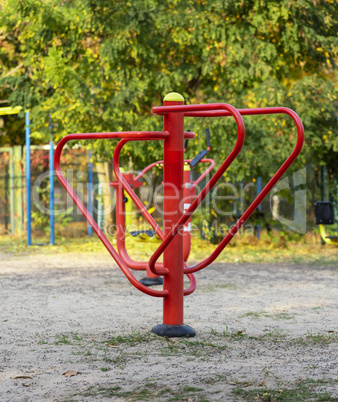 red iron sports simulator in a public park