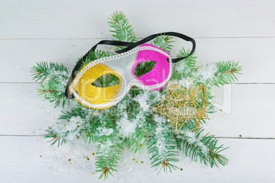 A wreath of fir branches, a mask and a decorative star on a whit