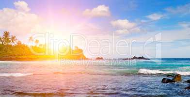 Sea landscape with rocky island and the sunrise. Beach. Wide pho