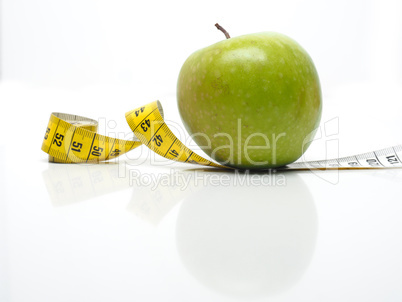 Green tasty apple with measuring tape