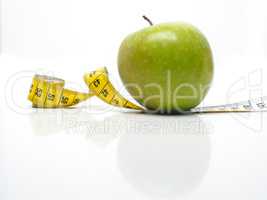 Green tasty apple with measuring tape
