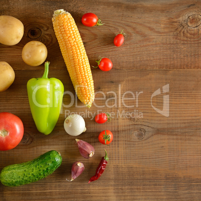 A set of vegetables laid out on a wooden table. Top view. Free s