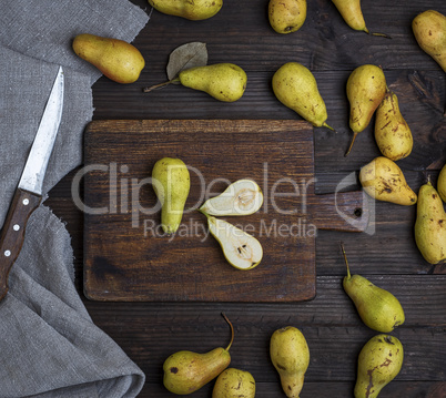 ripe green pears scattered on a brown wooden table