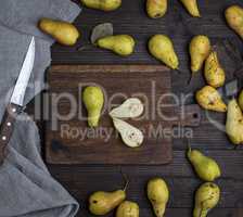 ripe green pears scattered on a brown wooden table