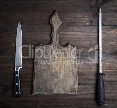 old brown wooden cutting board and knife with sharpening