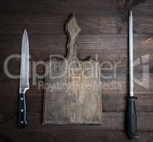 old brown wooden cutting board and knife with sharpening