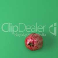 red pomegranate in the peel on a green background