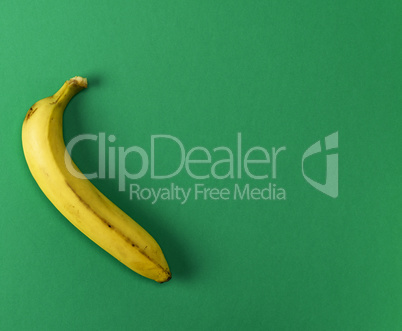 ripe yellow one banana on a green background