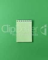 open small empty notebook on a green background