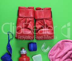 red leather boxing gloves, a plastic water bottle and a pink tow