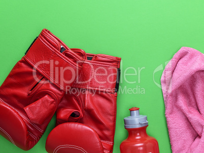 red leather boxing gloves, a plastic water bottle and a pink tow