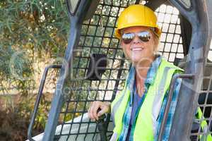 Smiling Female Worker Using Small Bulldozer At Constrcution Site