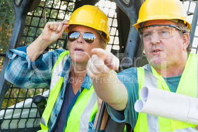 Male and Female Workers With Technical Blueprints Talking