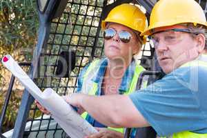 Male and Female Workers With Technical Blueprints Talking