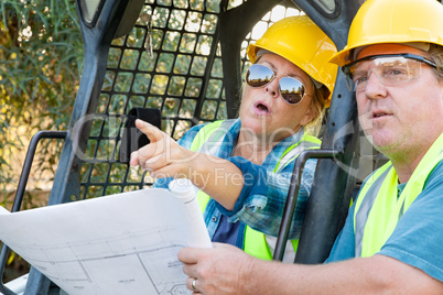 Male and Female Workers With Technical Blueprints Talking