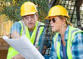 Male and Female Workers With Technical Blueprints Talking