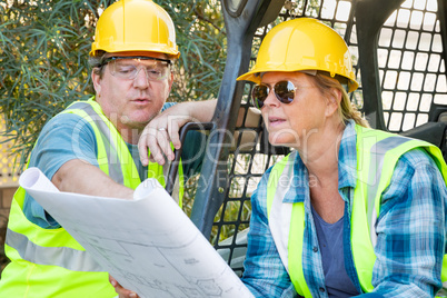 Male and Female Workers With Technical Blueprints Talking