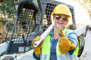 Smiling Female Worker With Thumbs Up and Technical Blueprints