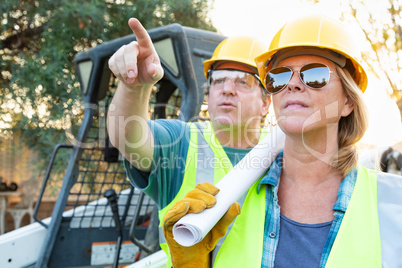 Male and Female Workers With Technical Blueprints Talking