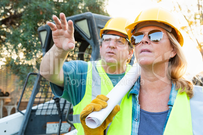 Male and Female Workers With Technical Blueprints Talking