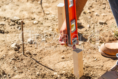 Worker Using Level At Construction Site