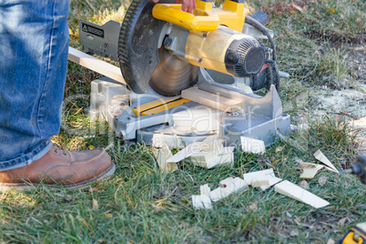 Worker Using Electric Miter Saw At Construction Site