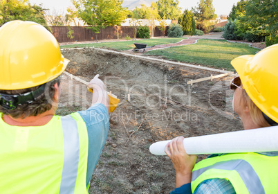 Male and Female Workers Overlooking Pool Construction Site