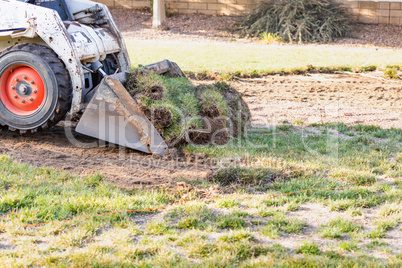 Small Bulldozer Removing Grass From Yard Preparing For Pool