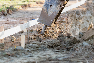Small Bulldozer Using A Breaker Attachment To Dig Hole