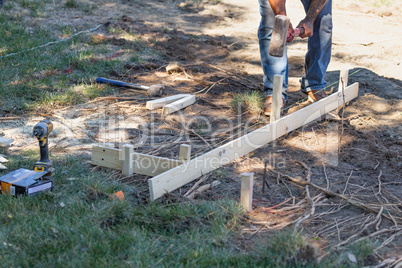 Worker Installing Stakes and Lumber Guides At Construction Site