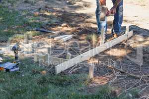 Worker Installing Stakes and Lumber Guides At Construction Site