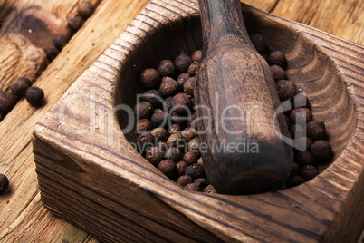 peppercorn in retro wooden mortar