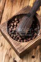 peppercorn in retro wooden mortar