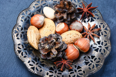 Christmas plate with nuts, spices and cedar cone