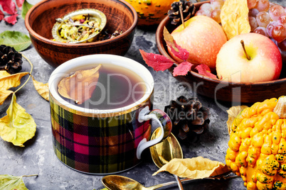 Cup of tea with autumn leaves